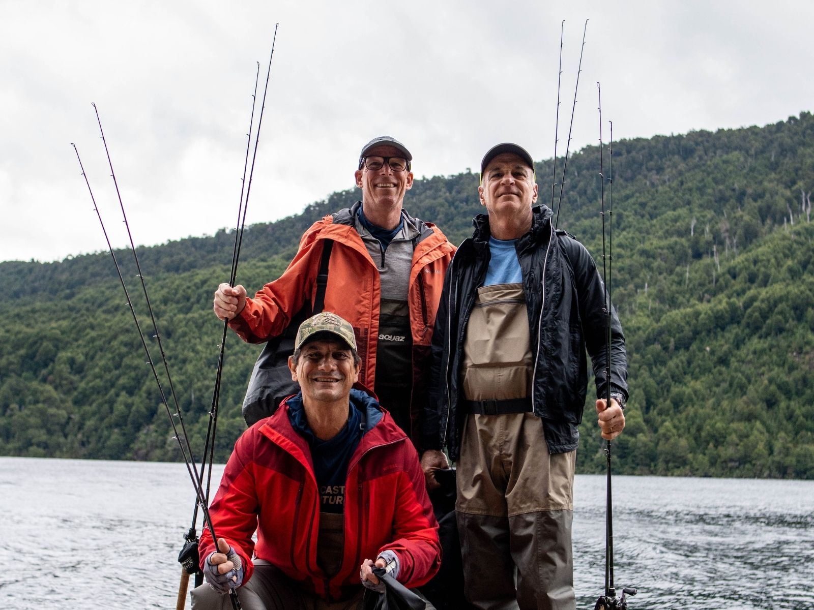 Equipo de Fly Cast Adventures junto a dos pescadores con cañas en mano frente al lago, listos para una jornada personalizada.