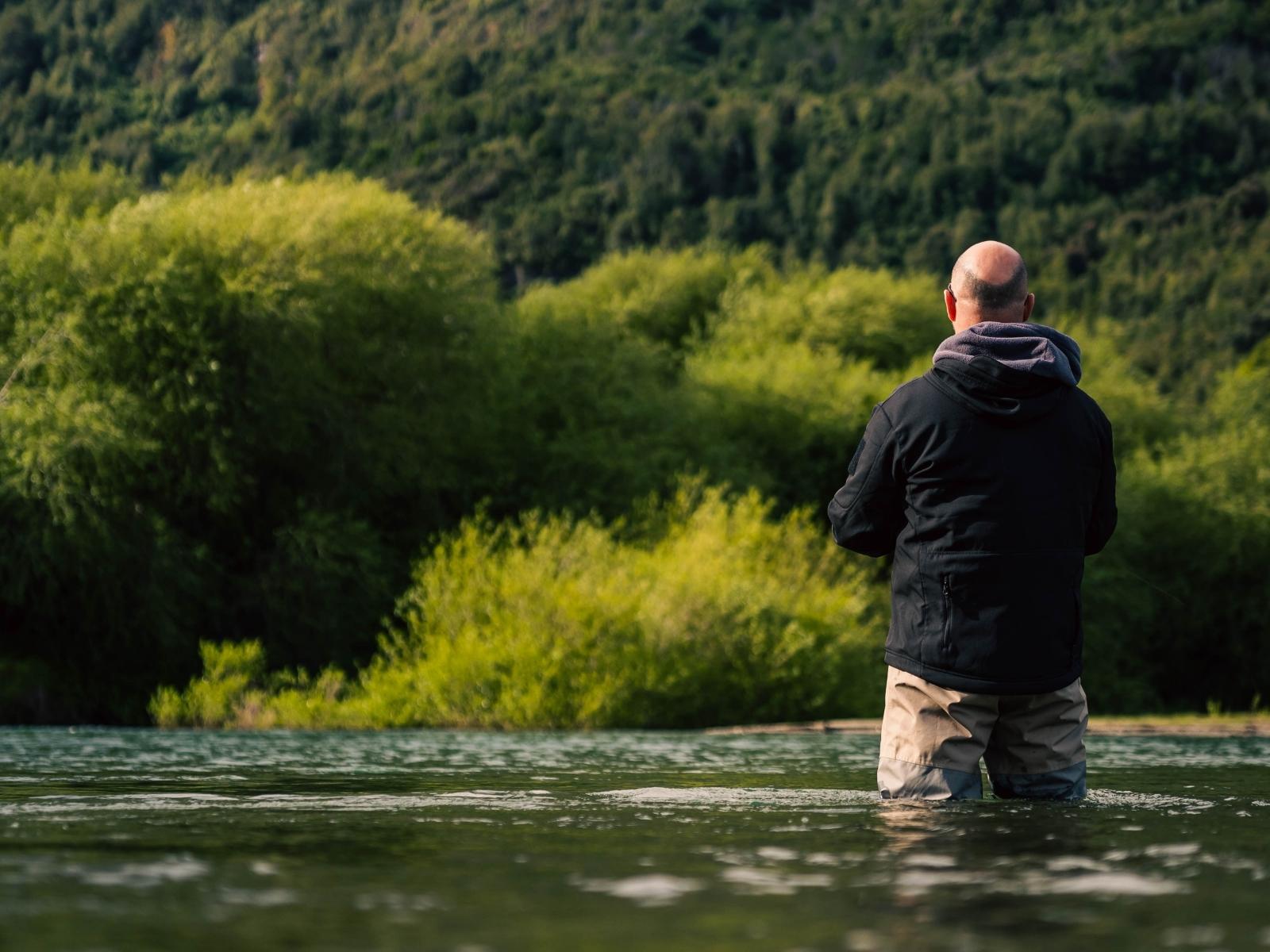 Pescador contemplando el río al amanecer